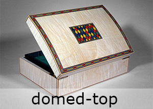 a domed top box veneered in figured maple and inlaid with dyed veneers made on a smartBoxmaker box making course